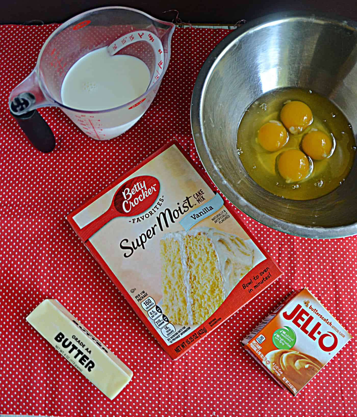 Eggs, cake mix box, a box of pudding mix, a stick of butter, and a cup of milk.