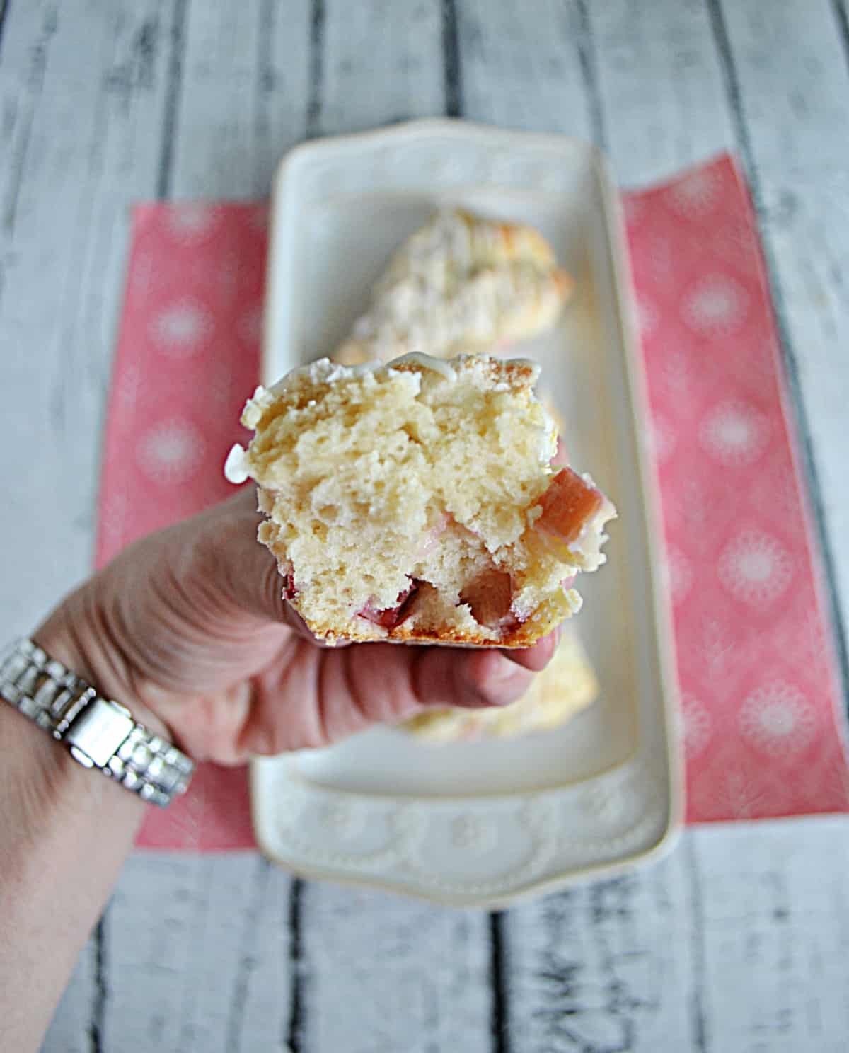 A close up of a hand holding a scone split apart