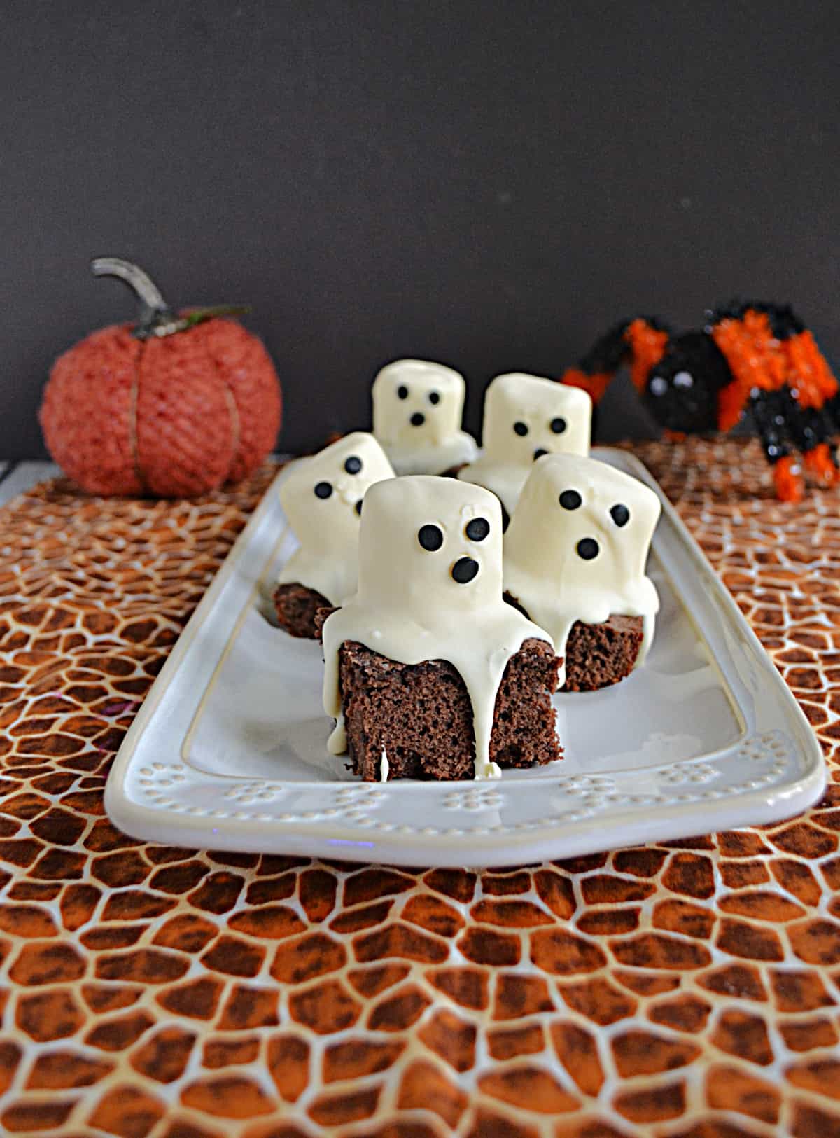 A front view of a platter of brownies with marshmallow ghosts on top.