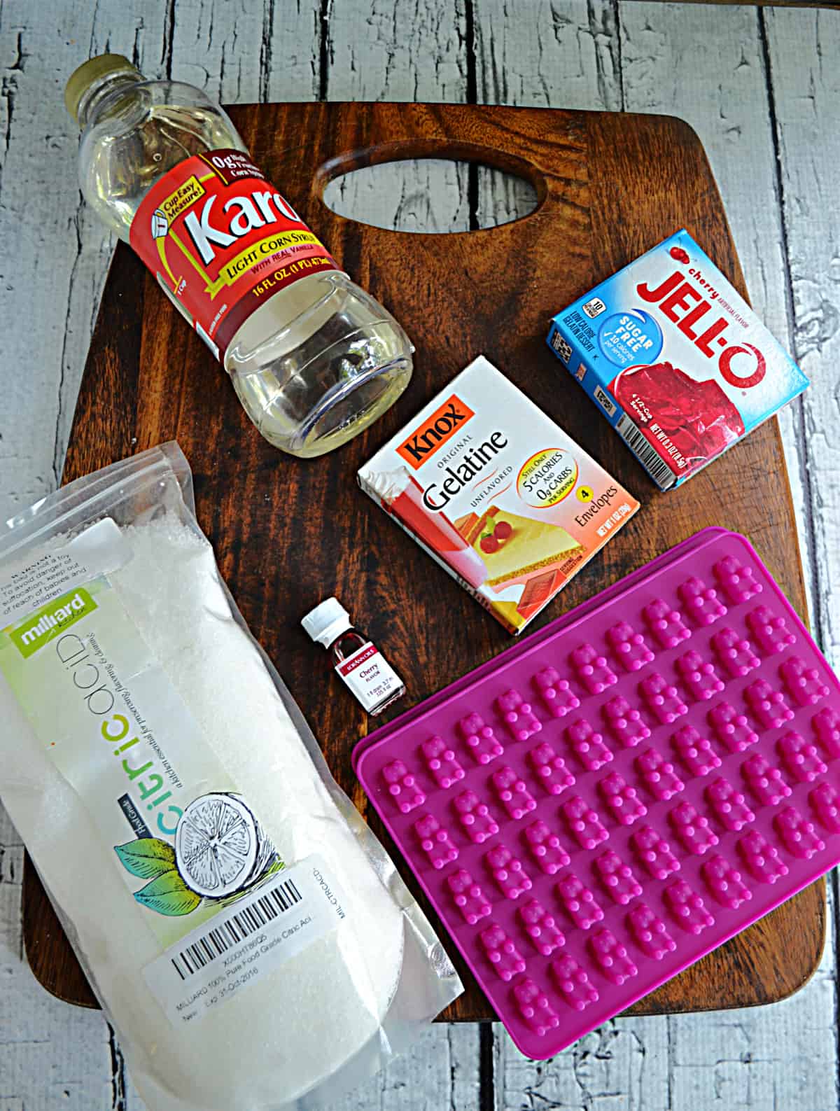 A cutting board with ingredients for making gummy bears.