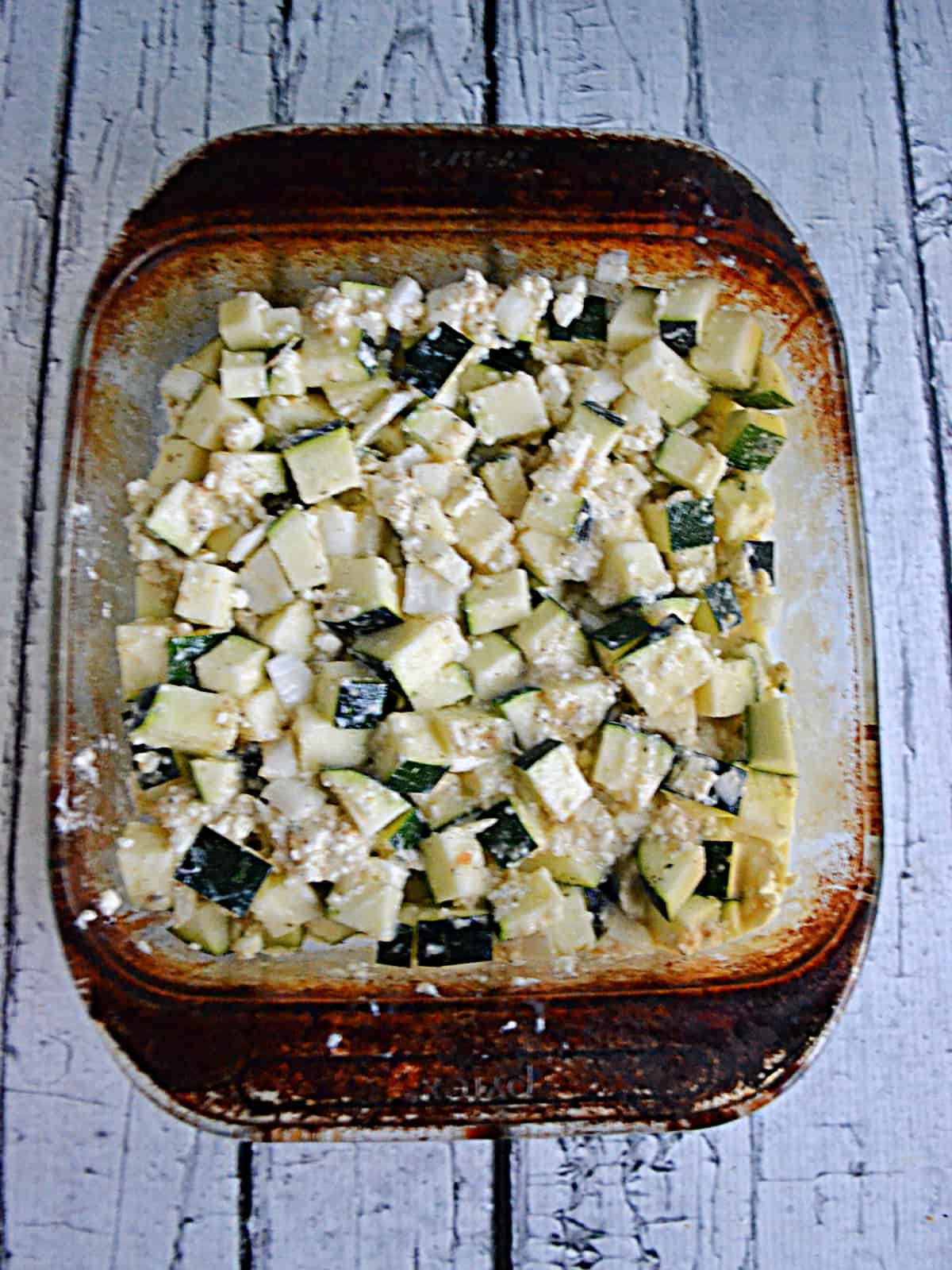 A dish with zucchini, cheese, and breadcrumbs.