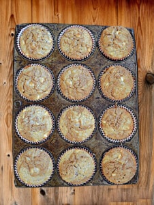 A muffin pan with 12 baked muffins.