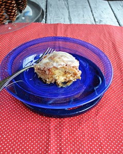 A plate with a cinnamon roll and a fork.