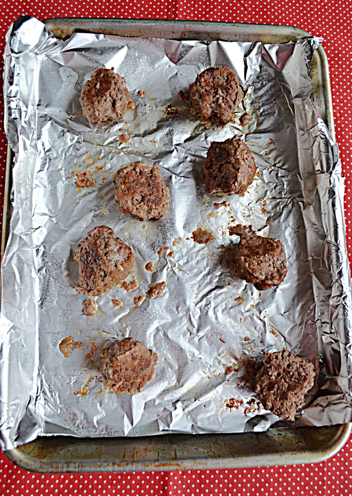 A baking sheet with meatballs on it.