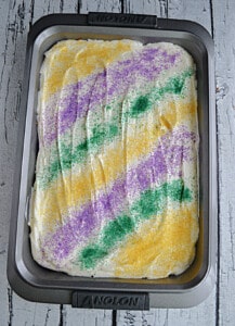 A Mardi Gras cake with yellow, green, and purple sprinkles.