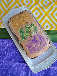 A loaf of Bananas Foster Bread with yellow, green, and purple sprinkles on top.