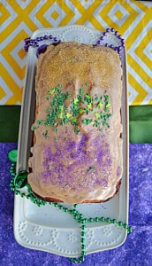 A top view of Banana Bread with rum glaze and yellow, green, and purple sprinkles.