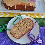 A slice of Bananas Foster Bread with green and purple beads around it.