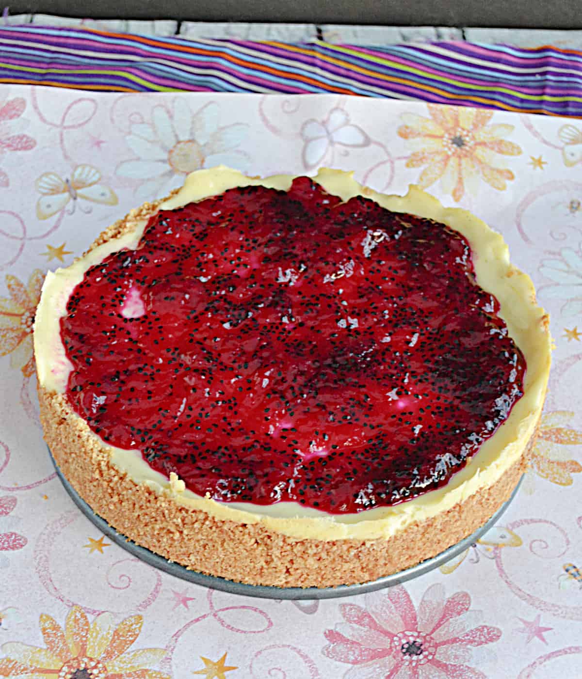 A vanilla bean cheesecake with dragon fruit jam on top.