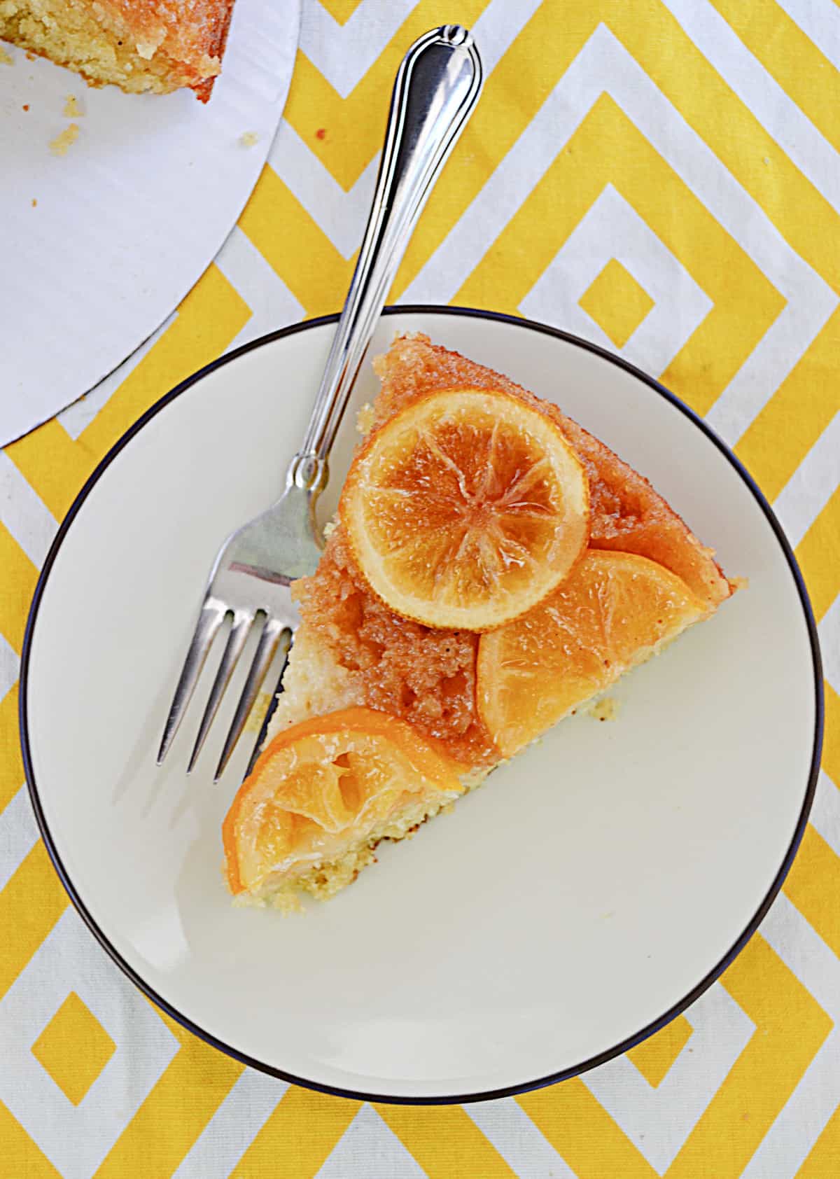 A slice of lemon upside down cake with a fork next to it.