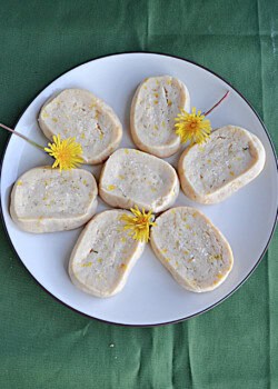 A plate of dandelion cookies with the dandelions on the plate.