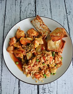 A plate of fried rice, baked chicken, egg roll.