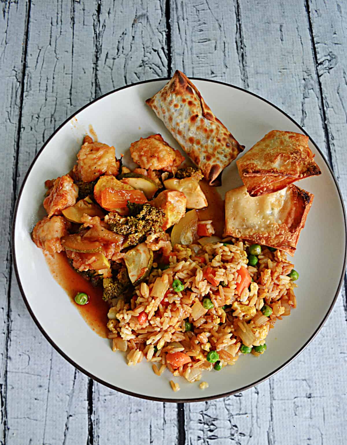 A plate of fried rice, baked chicken, egg roll.