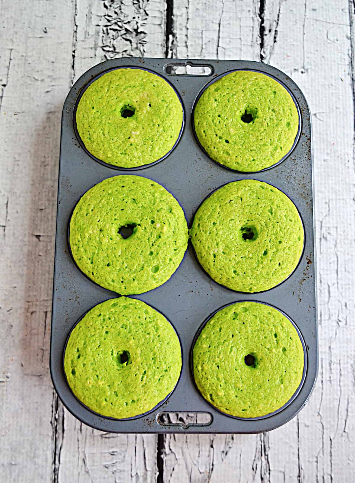 A pan of baked green donuts.