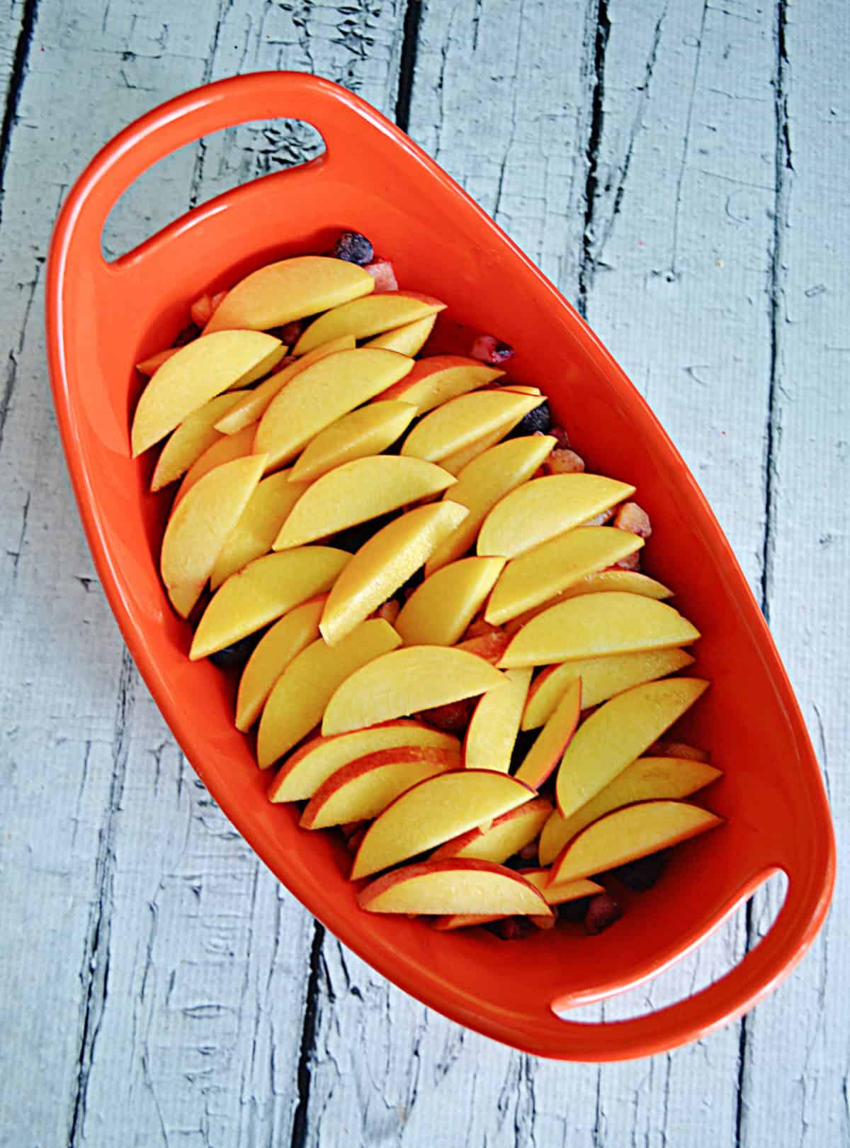 A dish with sliced peaches in it.