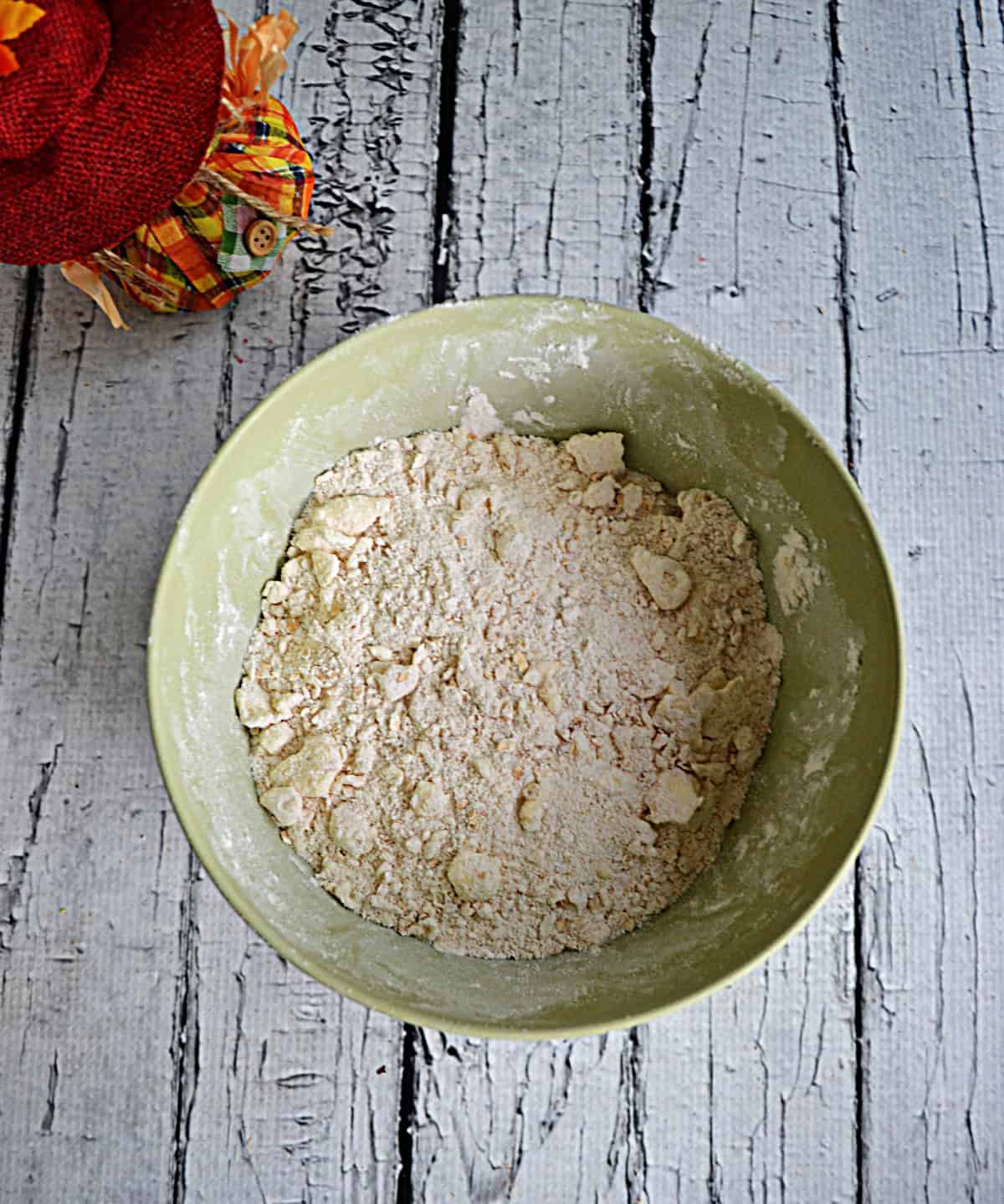 A bowl of flour and butter mixed together.