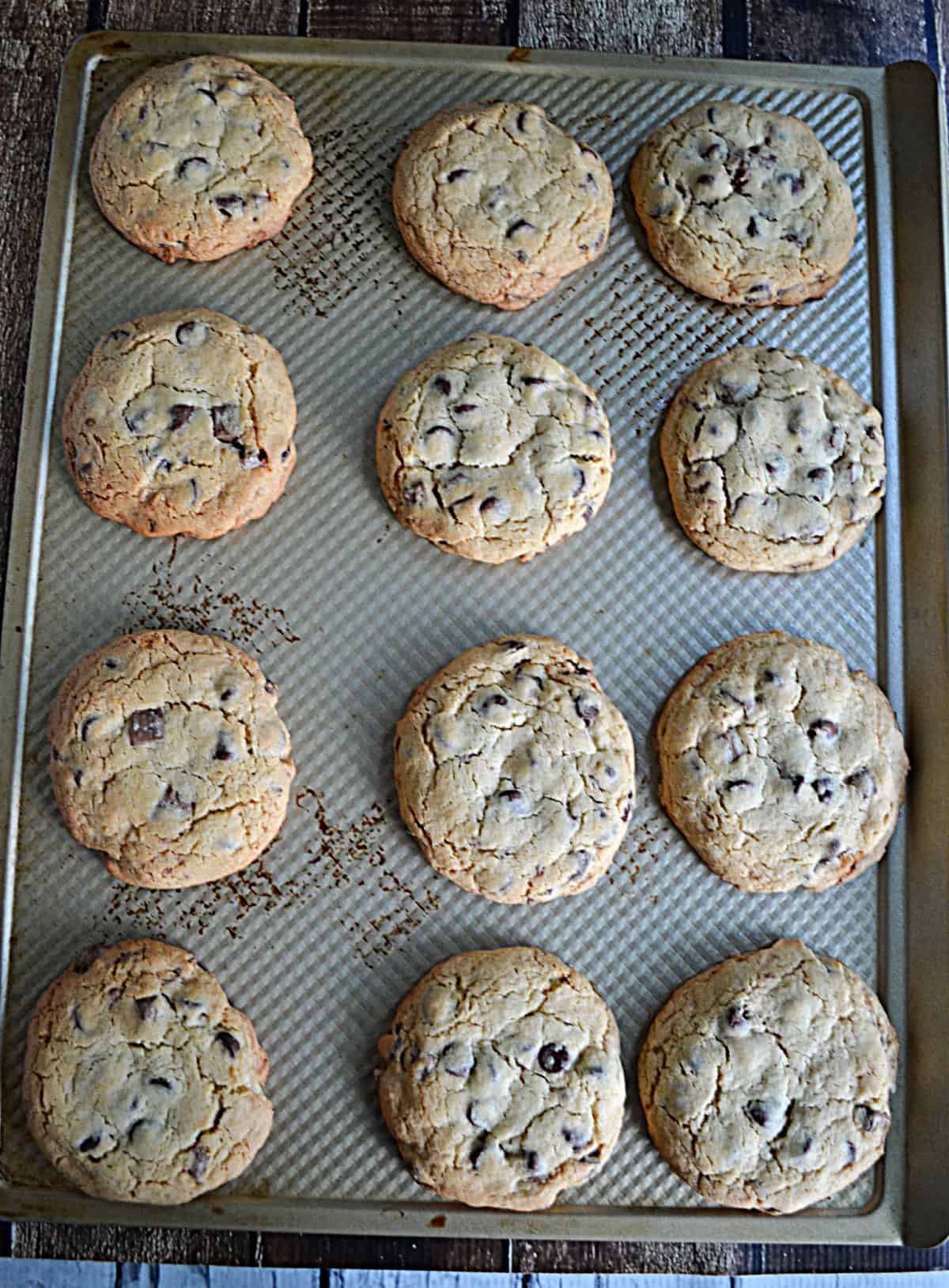 A baking pan with baked chocolate chip cookies on it.