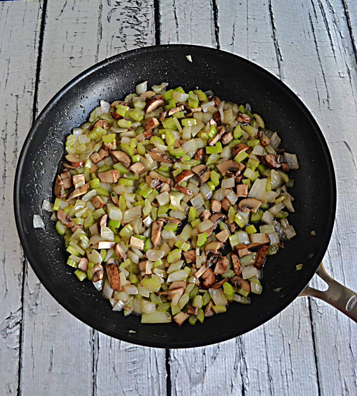 A skillet with mushrooms and onions in it.