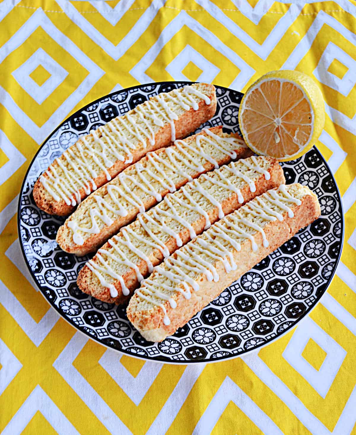 A plate of biscotti with a lemon on the plate.