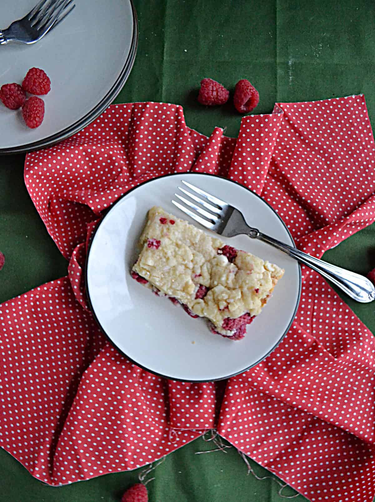 A plate with a raspberry cookie bar and a fork.