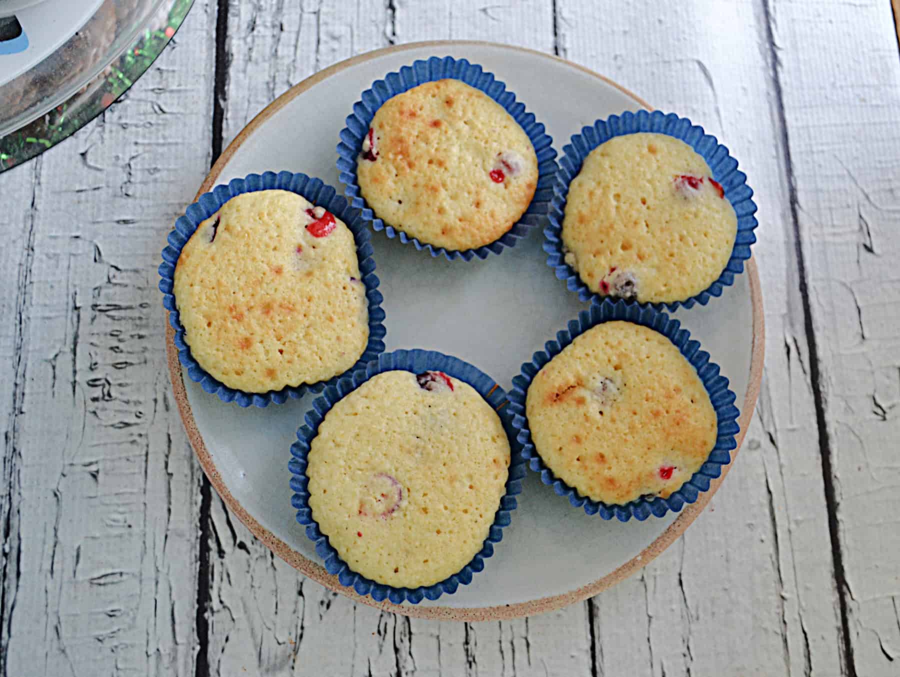 An overhead view of a plate of cranberry orange muffins.