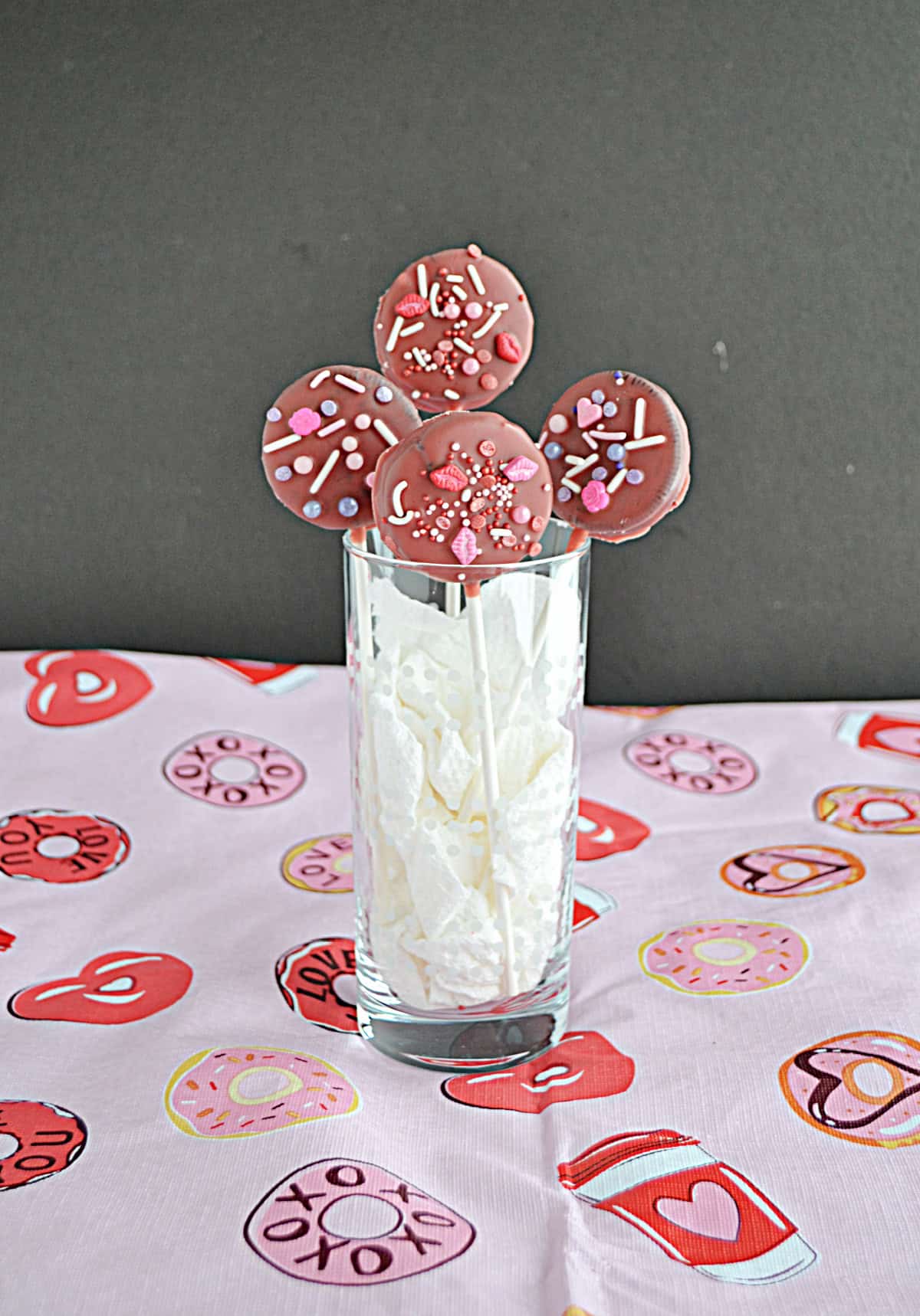 A glass full of Chocolate covered Oreo Pops.