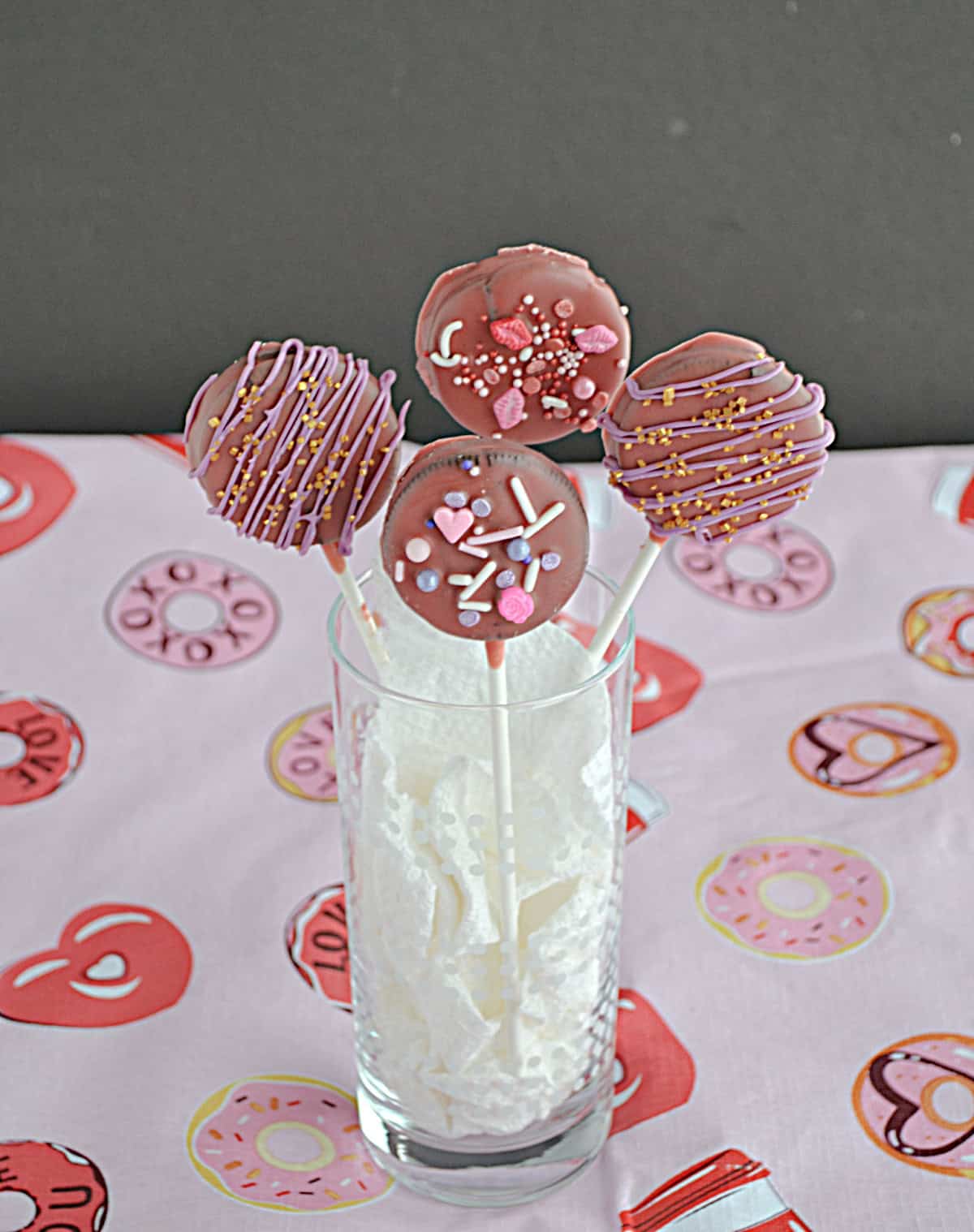 Four Chocolate Covered Oreo Pops in a glass.