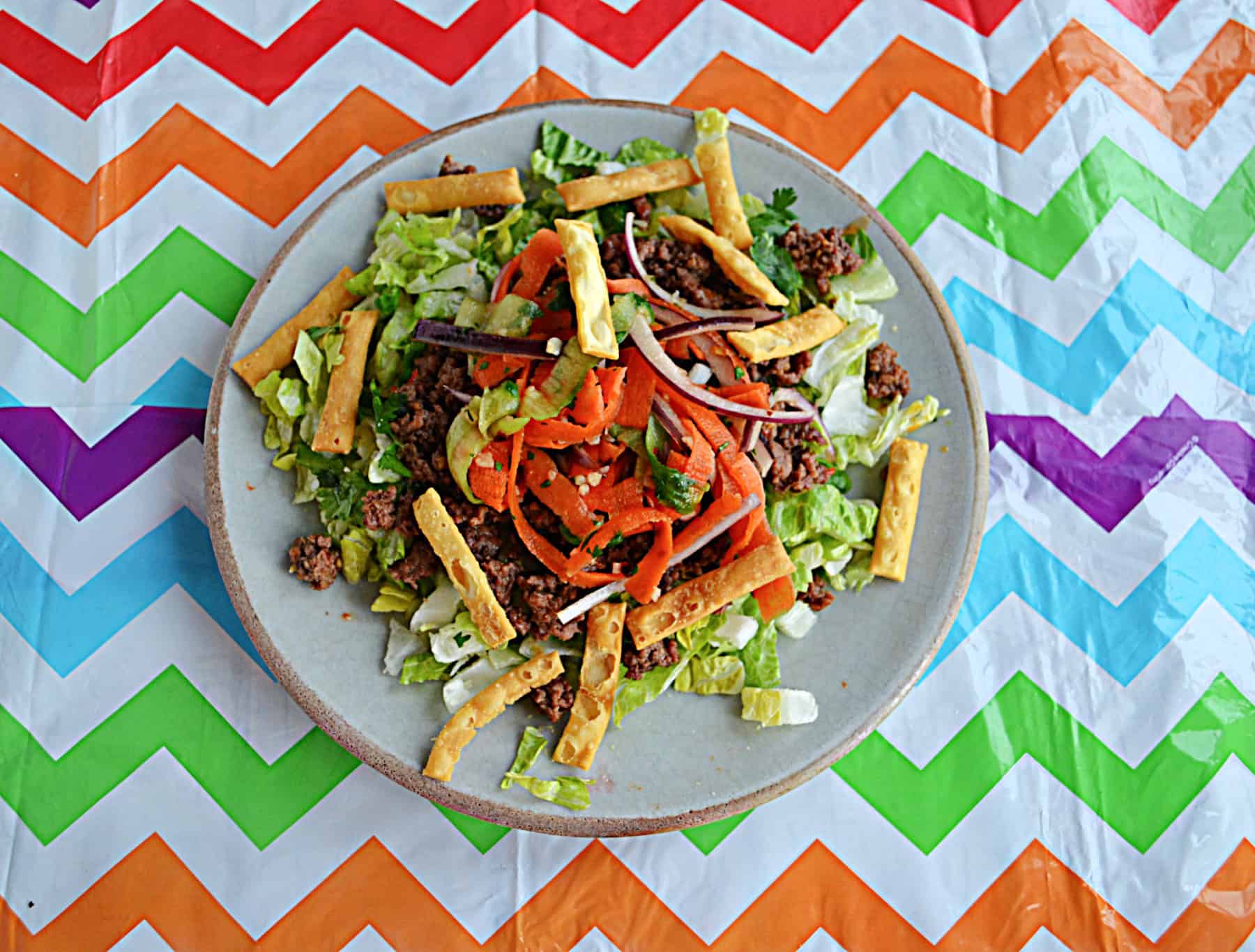 A salad with beef and carrot dressing.