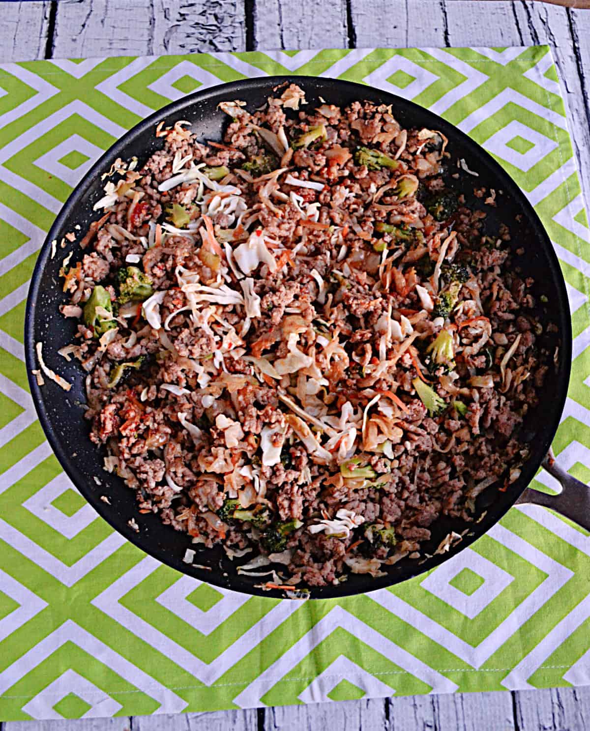 A skillet of broccoli, cabbage, and ground pork.
