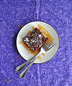 A plate with a brownie and two forks.