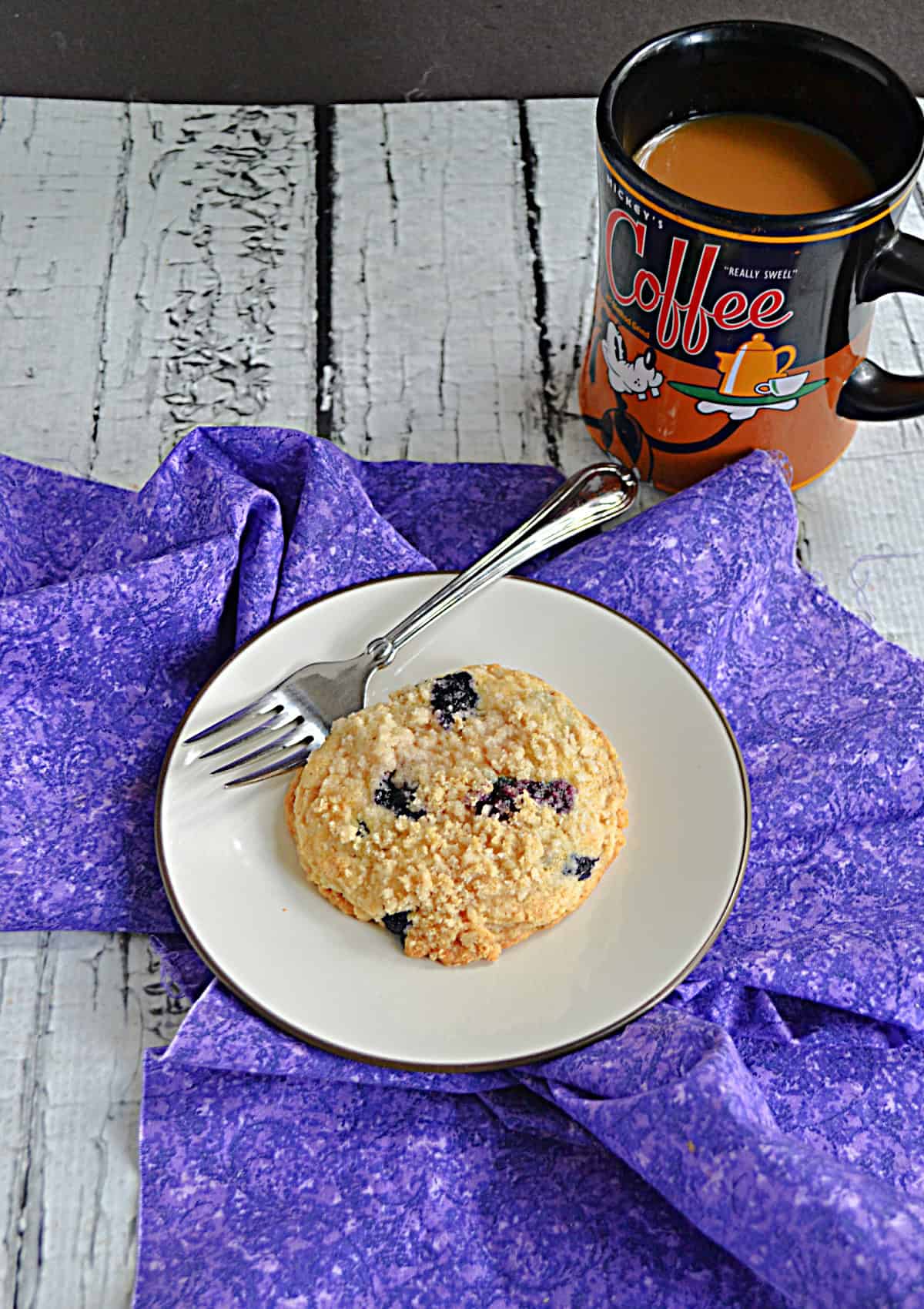 A plate with a cookie and a cup of coffee.
