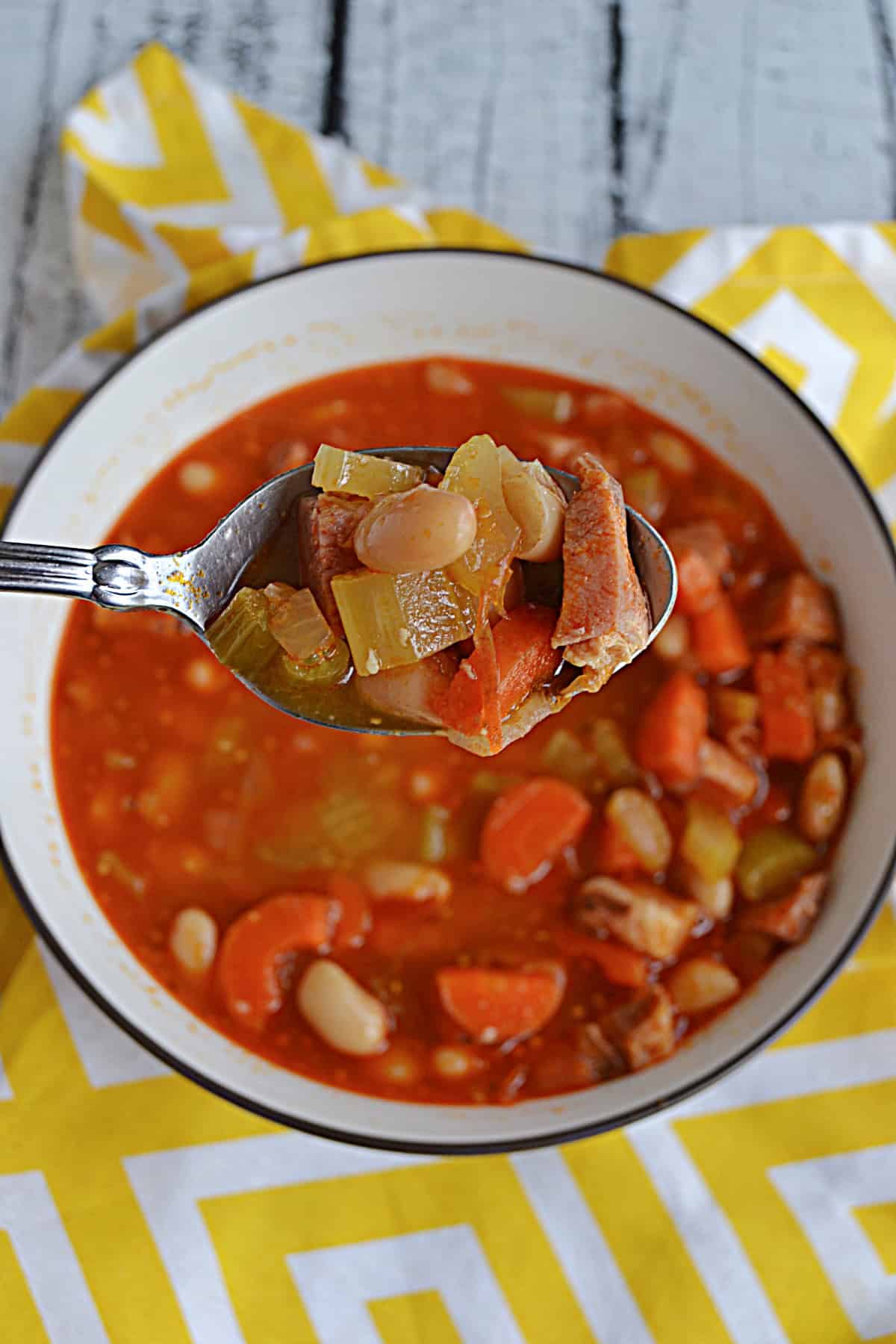 A spoon holding a scoop of soup up close.