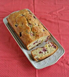 A platter with a loaf of cherry bread on it.