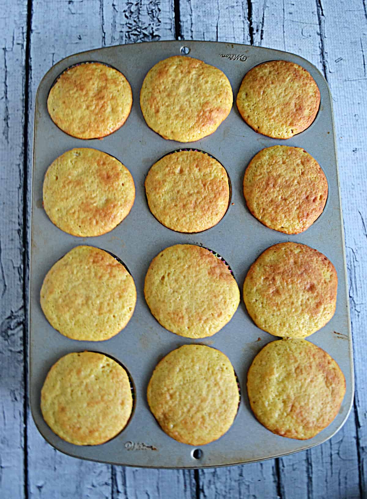A muffin tin filled with baked cupcakes.