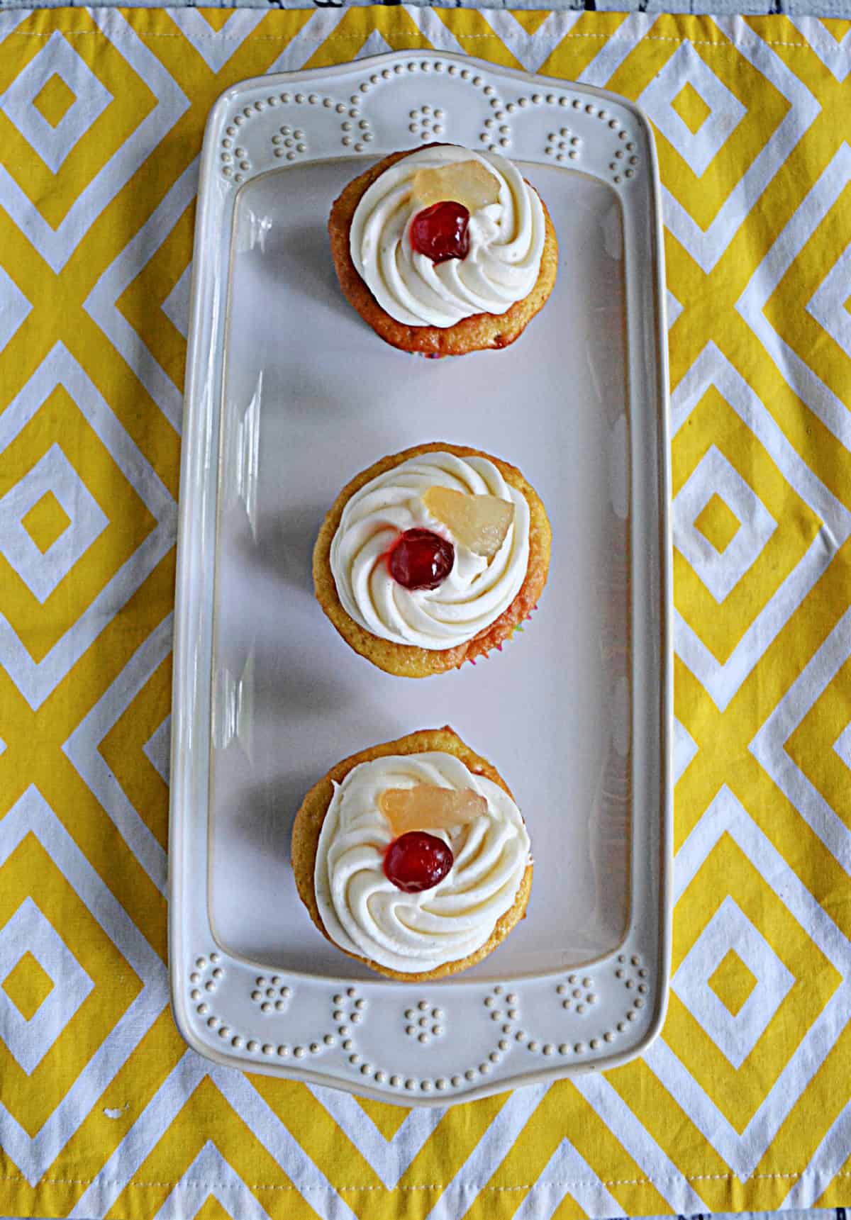 A platter with three cupcakes on it.