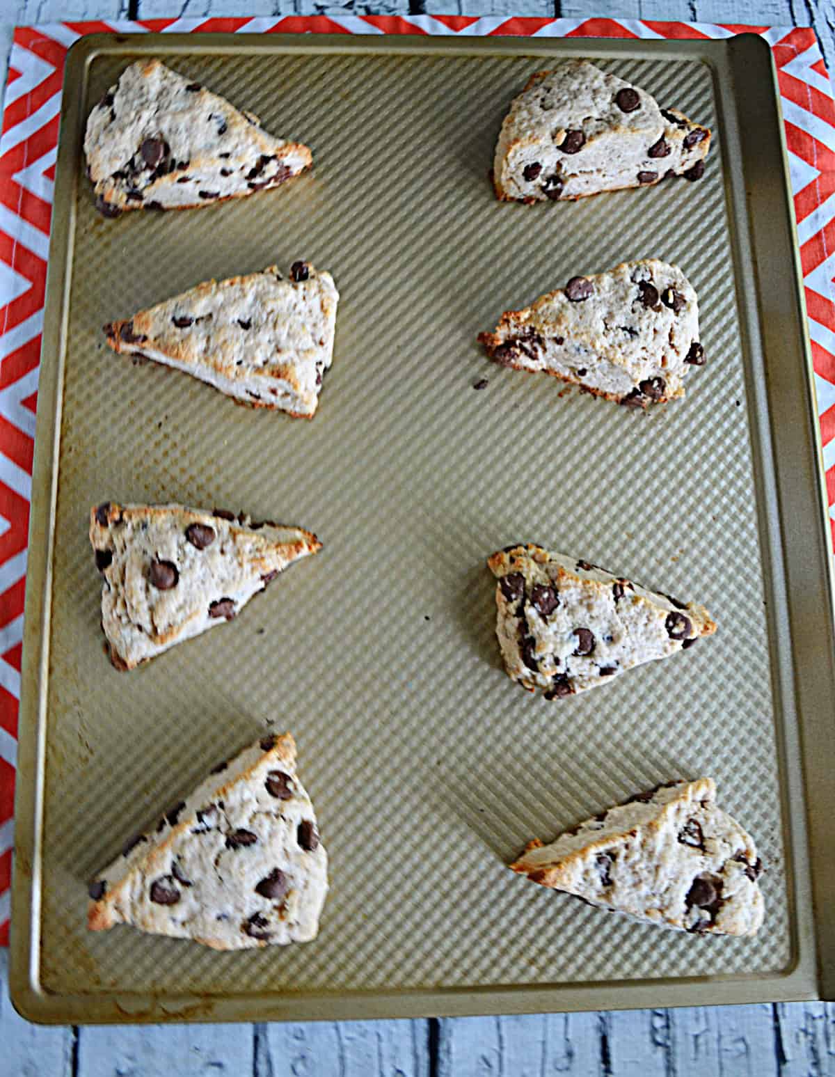 A baking sheet with baked scones on it.