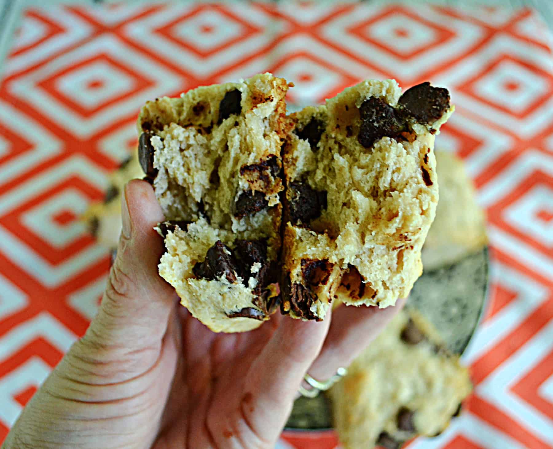 A hand holing a scone broken in half.