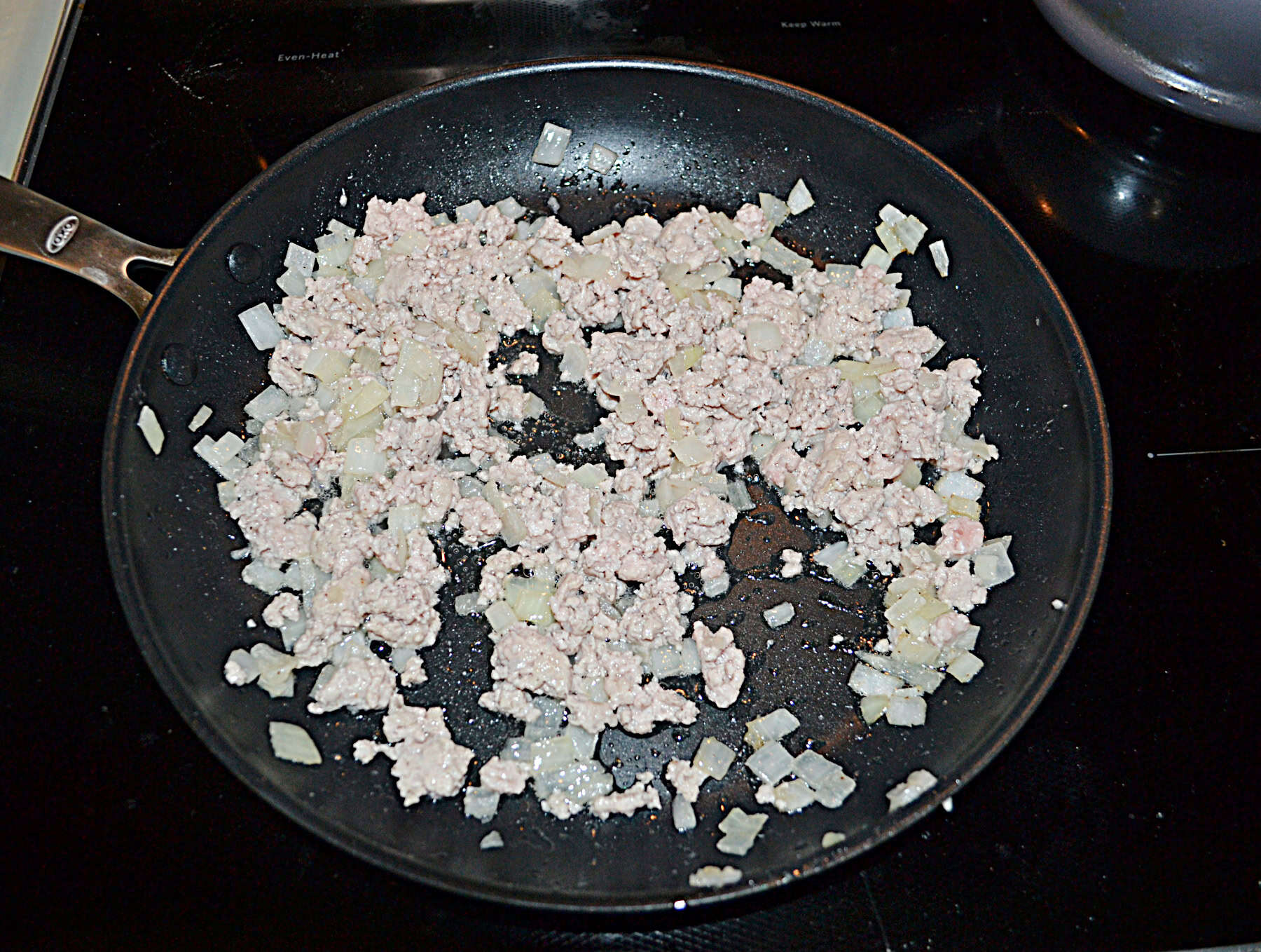 Ground pork in a skillet.