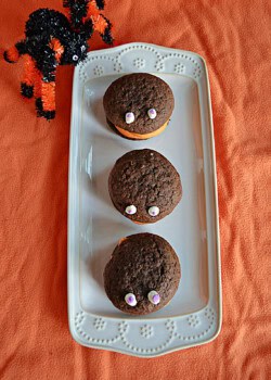 A platter with three chocolate whoopie pies with eyes on them.