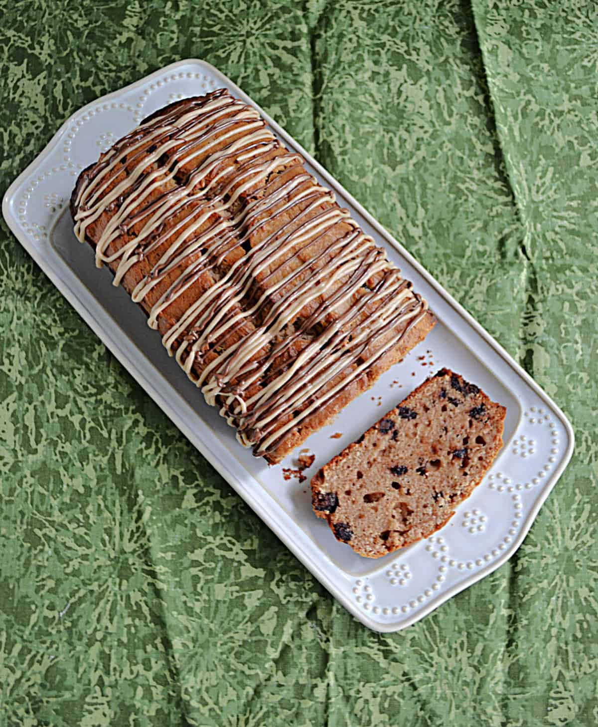 A white platter with peanut butter chocolate chip bread on it.