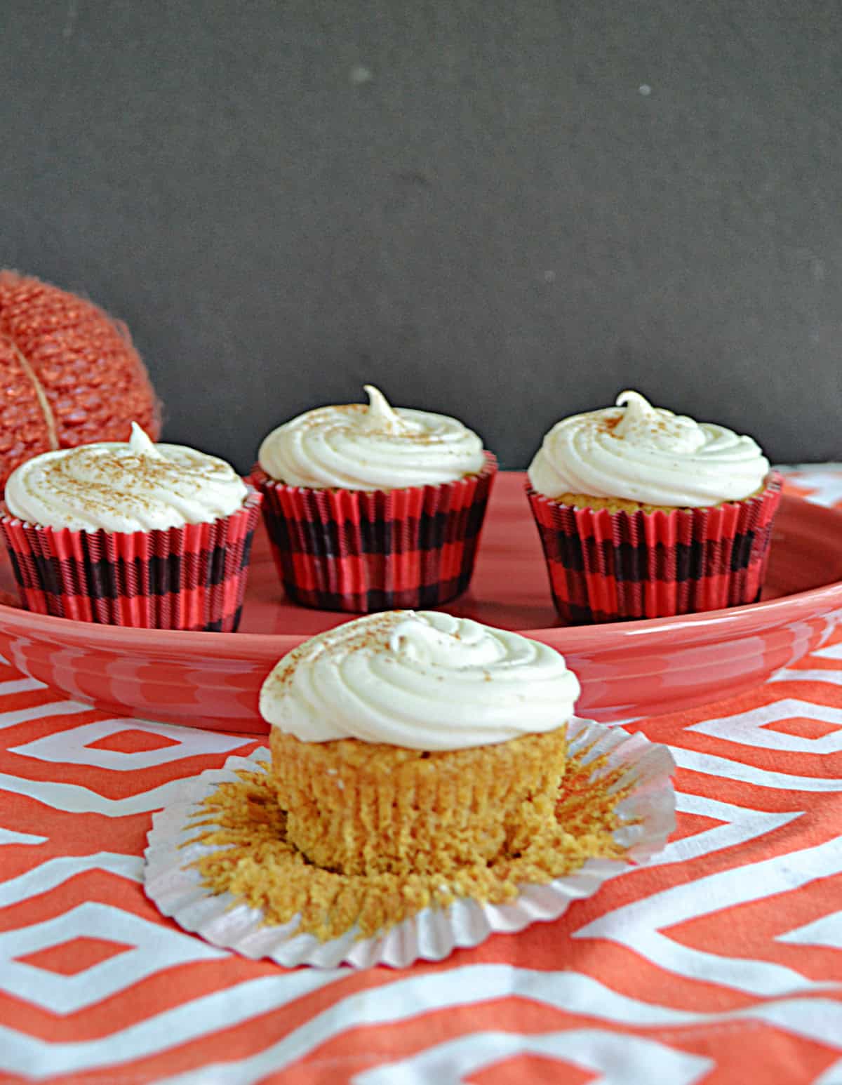 A close up of a cupcake with a platter of cupcakes in the background. 
