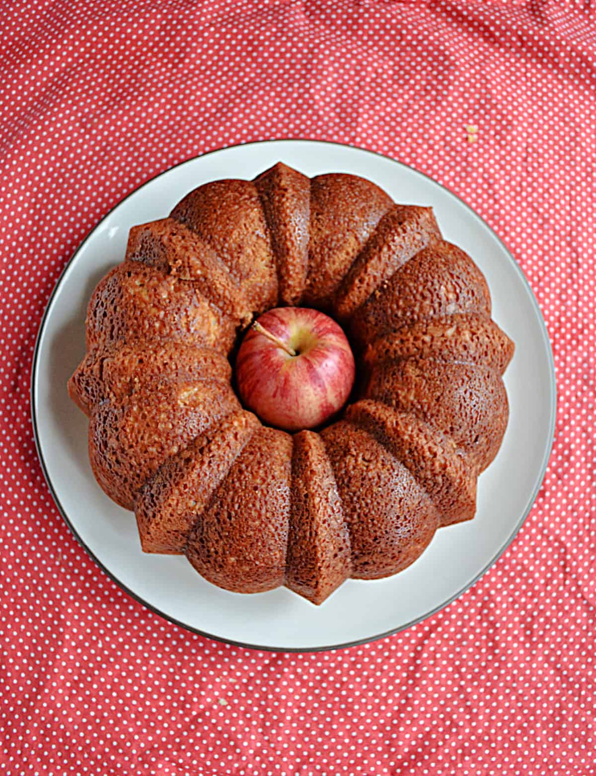 A golden brown Bundt cake with an apple in the middle of it.