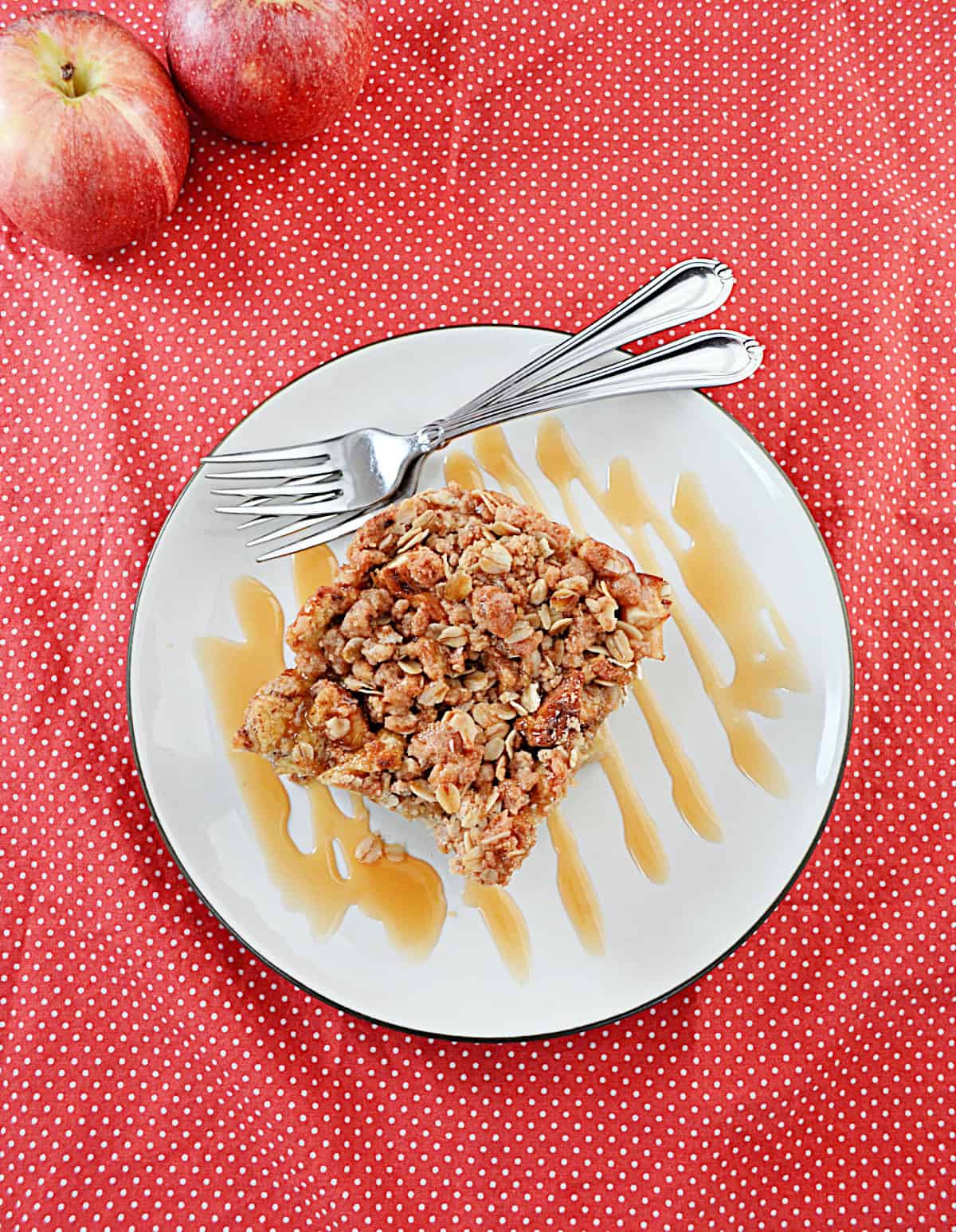 A plate with a slice of French toast, caramel drizzle, and two forks on it.