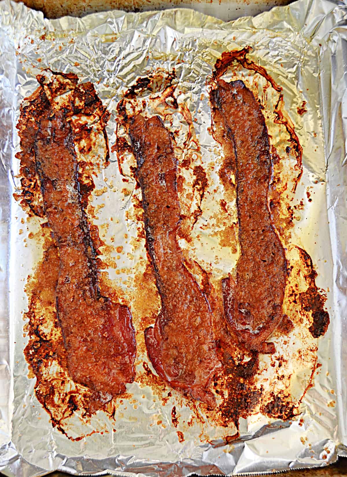 Bacon caramelizing on a baking sheet.