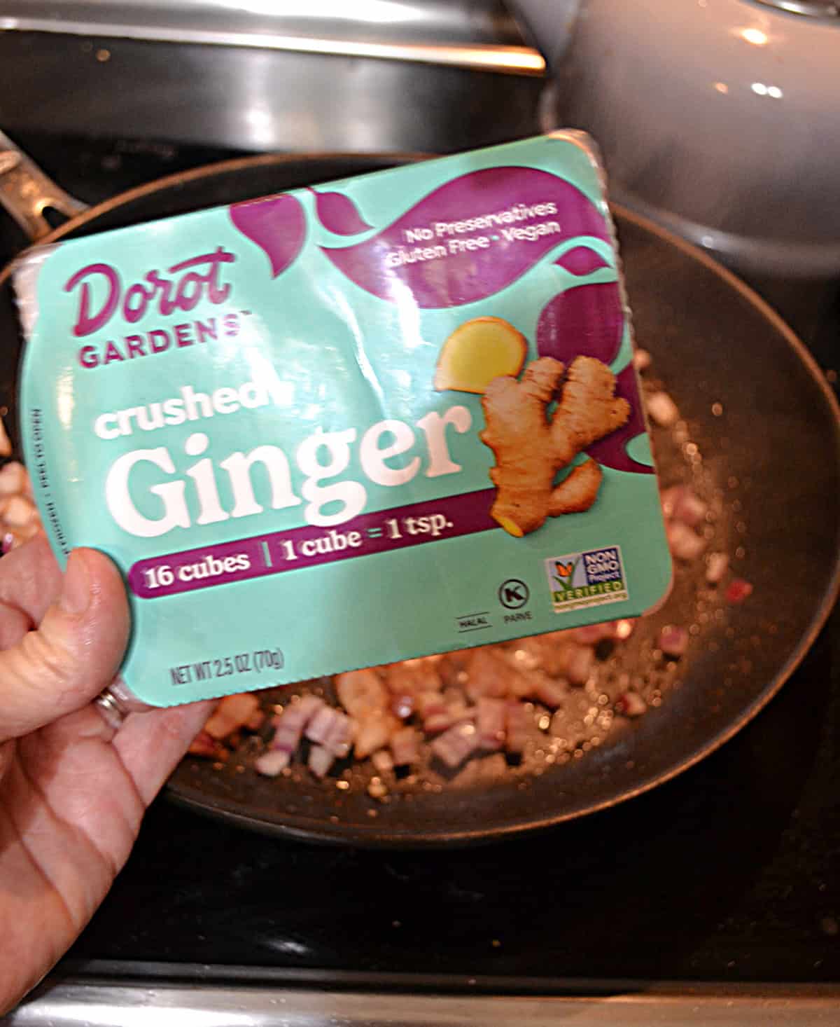 A hand holding a package of Dorot frozen ginger.