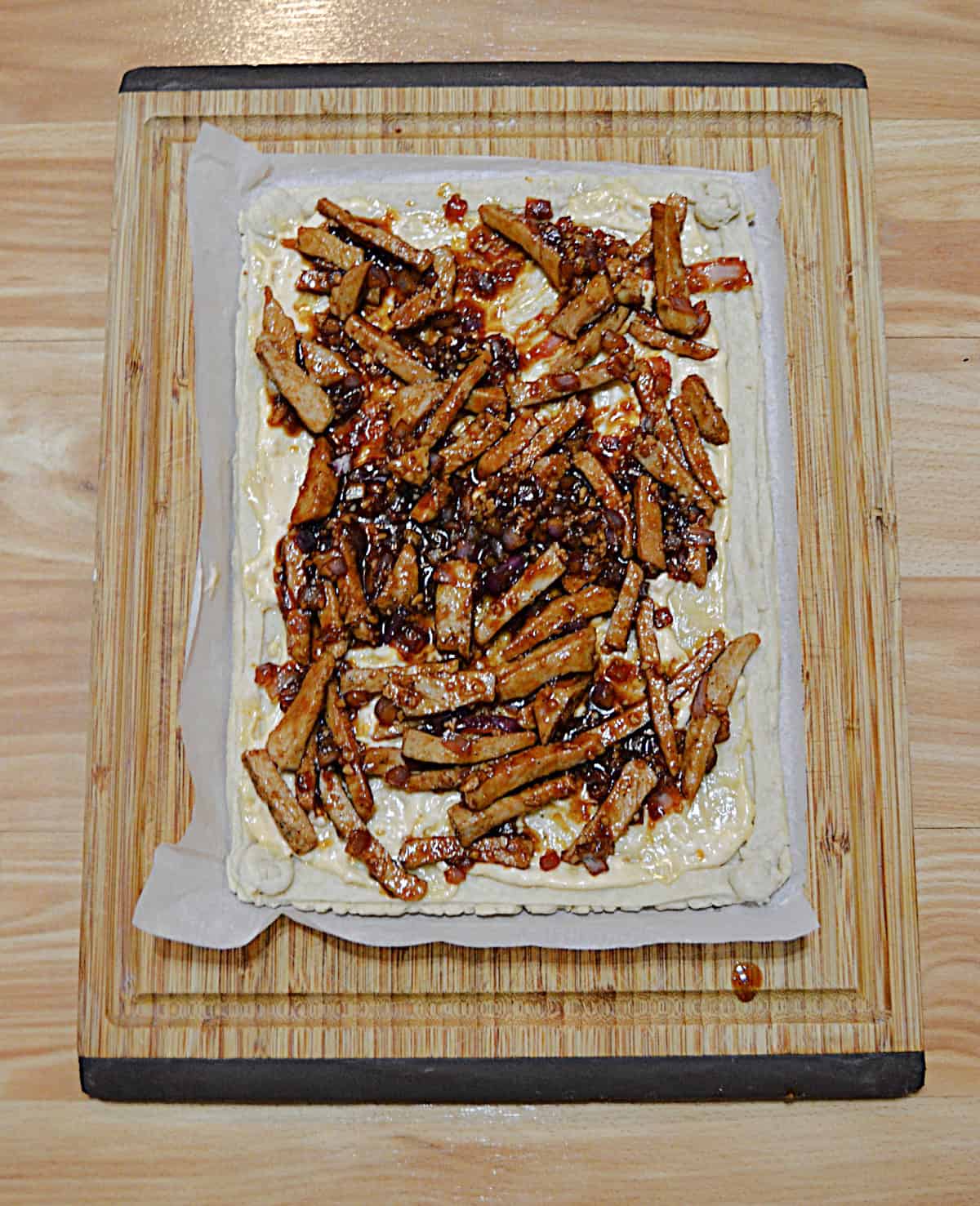 A tart shell with pork on top of it.