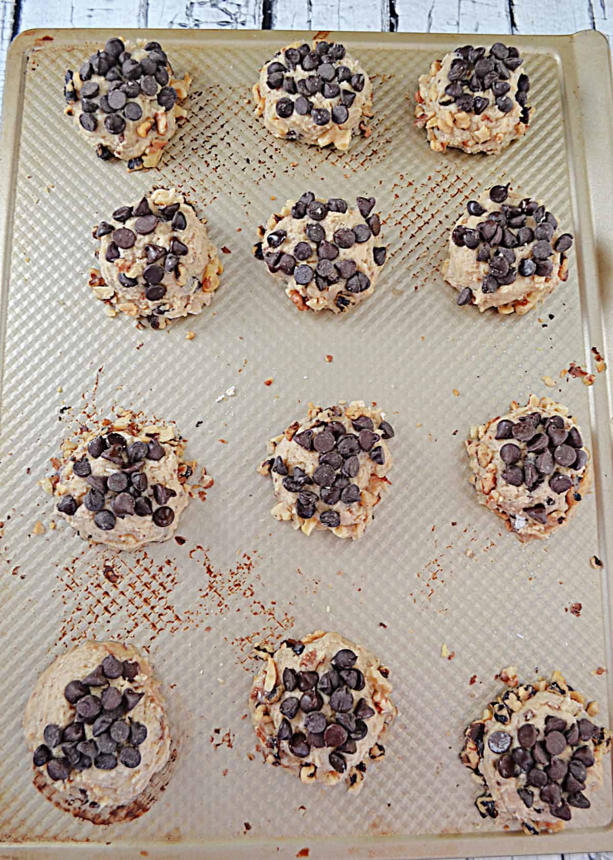 A baking sheet with chocolate chip cookie dough on it.