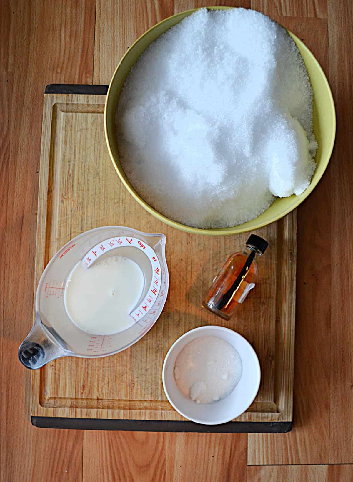 A bowl of snow, a cup of milk, a bowl of sugar, and vanilla.