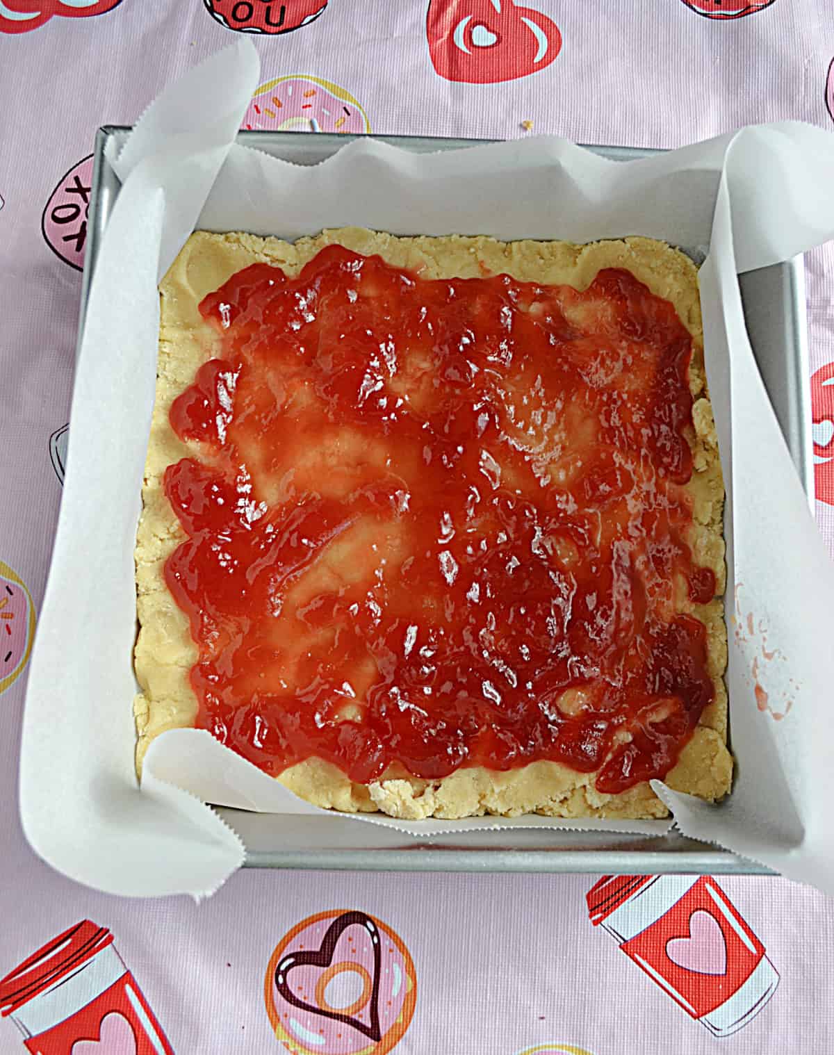 A pan with crust and strawberry jam in it.