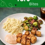 Pin Image: Title, a plate wit tofu bites, sauce, couscous, and Brussels sprouts.